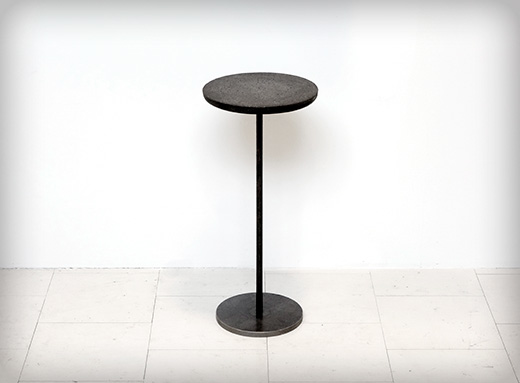Runt litet bord eller rund sittpall av svart betong